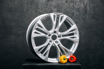 Car rims at the dark background with yellow pepper