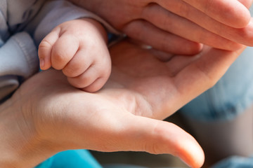 Hands of the child and the mother close-up. Parental care. Hand to hand. Grasp