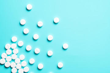 scattered white pills on a blue background. background with pills.