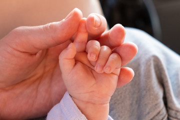 Hands of the child and the mother close-up. Parental care. Hand to hand. Grasp