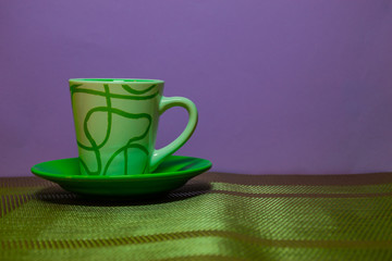 green coffee cup on purple background
