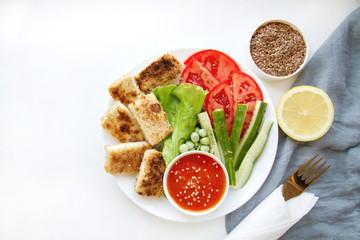 Vegan food. Fried tofu with vegetables and spice sauce. Healthy food on a plate. Wholefoods