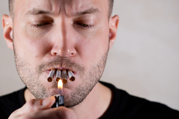 unshaven man macho lights four cigarettes at once