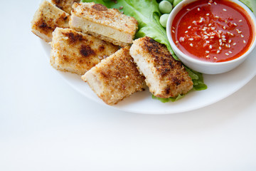 Delicious vegan food: baked tofu sticks, fresh salad, peas and chili sauce. Healthy meal