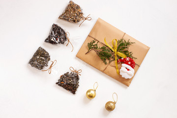 New year flatlay 2020. Christmas tea gifts box wrapped in eco kraft paper with pine tree. Mock up template design.Winter holiday decorations, trendy minimal style.Different teas tastes and flavors. .