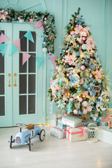 Close up a Christmas tree lights glittering at night. New Year fir tree with decorations and illumination. Xmas tree decorations background. Many large golden balls on fir tree New Year and Christmas