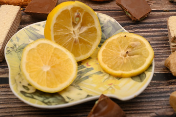 Fototapeta na wymiar sliced lemon on a saucer and on a wooden background. Close up.