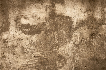 Brown shabby concrete wall. Peeling stucco, background. Abstract plaster texture. Ruined facade of a building. Faded paint.