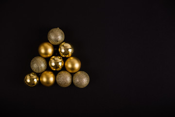 Christmas balls and garlands on a black background. New Year and Christmas backgrounds with copy space, flat lay.