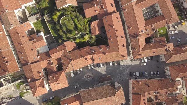 Top down aerial view of a small historic town Venzone in Northern Italy with red tiled roofs of old buildings.