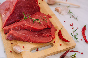 Fresh pork raw fillet on wooden board. Red beef meat on a cutting board.