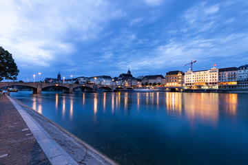 Obraz premium Switzerland, Basel, Unterer Rheinweg, 27 July 2019. Panoramic view across the rhine river at the skyline of the old town of Basel during sunrise.