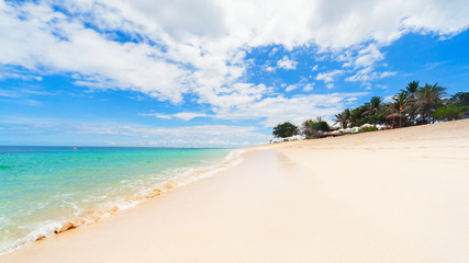 Scenic view of tropical beach with clear turquoise water and white sand. Niko beach is popular place for day tours. Nature of Bali island, best travel destinations on family vacation in Indonesia.