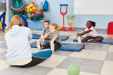 Gruppe Kinder macht Übung zum Dehnen