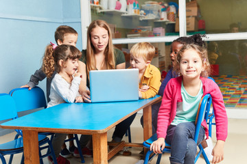 Kinder spielen und lernen zusammen am Laptop - obrazy, fototapety, plakaty