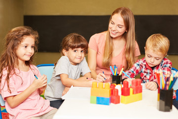 Fototapeta premium Kinder Gruppe und Erzieherin malen zusammen