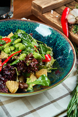 Green vegetarian salad in a beautiful bowl on a wooden background. A tasty and healthy snack for lunch. Close up view. Healthy food