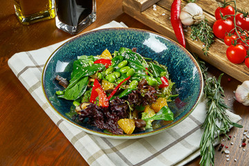 Green vegetarian salad in a beautiful bowl on a wooden background. A tasty and healthy snack for lunch. Close up view. Healthy food