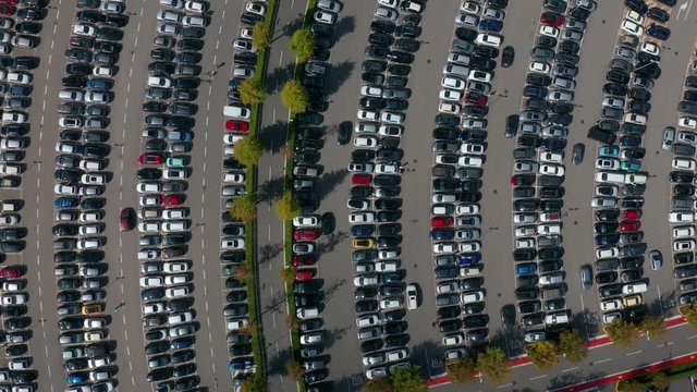 Aerial top view of the supermarket parking lot with lots of cars.