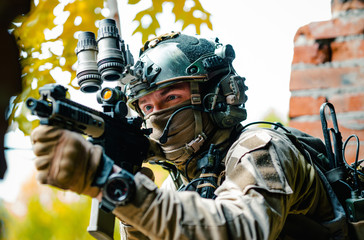 Closeup airsoft man in uniform, move with machine gun. Soldier aims at the sight