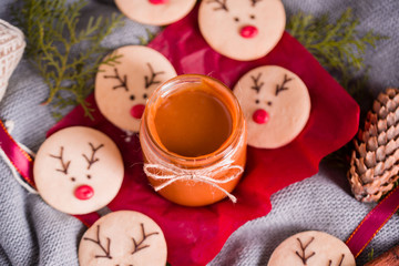Christmas cookies with homemade salted caramel on a wooden background, neon lights, cinnamon sticks.