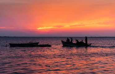 Fototapeta na wymiar Red sky and fishermen. Fishermen are leaving at sunset.