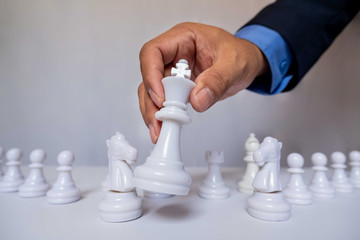hand of businessman moving chess in competition, shows leadership, followers and business success strategies