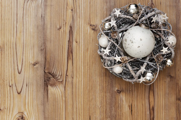  Adventskranz und Christbaumkugel auf alter Holzplatte als Weihnachtshintergrund für Postkarten oder Poster