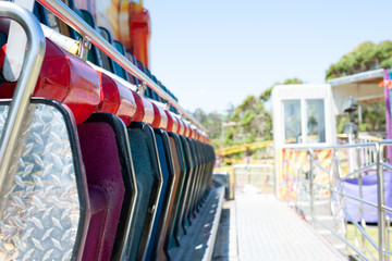row of coloured chairs in park 