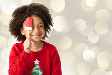 Happy adorable african american child girl celebrates christmas on light background