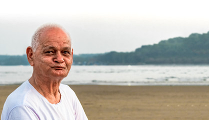 Old Indian Man, Super Senior Citizen in his mid 80s, posing to camera making happy faces. He has...