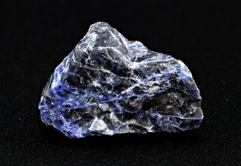 Black and blue sodalite mineral stone specimen on a black background