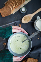 female hands hold a plate with soup in their hands. Winter food concept. Food for warming.