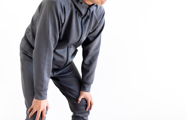 膝に手を置いて休憩している灰色のジャージを着た男性