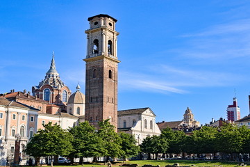 Fototapeta na wymiar Turin Cathedral with Guarini Dome, bell tower and Roman walls remains seen at sunset from the Palatine Gate park