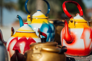 preparing arabian coffee and tea on an open fire with colorful pots 