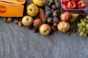 .Top view to fall fruits over a grey background with copy space.