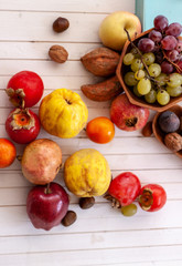 Top view to fall fruits over a white wooden background with copy space.