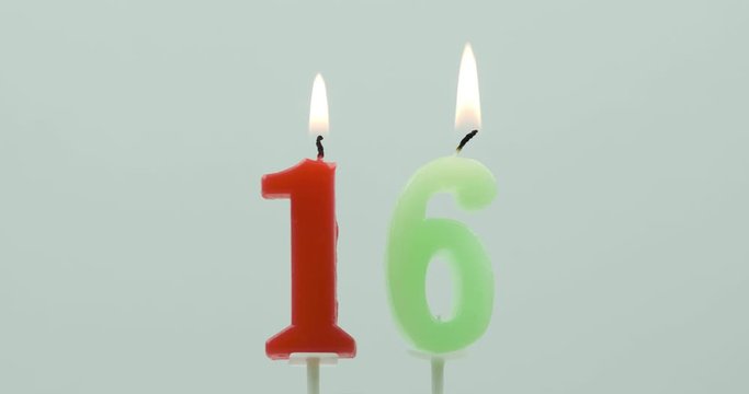 Birthday candles celebrating 16th birthday against a grey background