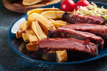 Spicy barbecued pork ribs served with french fries