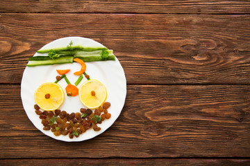 Fresh organic vegetables and fruits on dish over rustic background, top view, place for text. Healthy lifestyle concept - vegetable bike on dish on wooden.