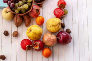 Naklejka na ściany i meble Top view to fall fruits over a white wooden background with copy space.