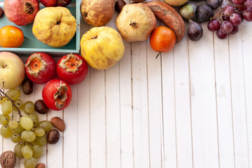 .Top view to fall fruits over a white wooden background with copy space.