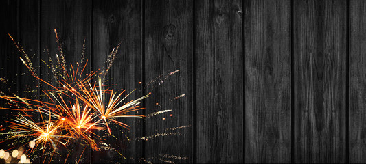 Festive silvester background banner panorama - Firework on a rustic black wooden texture, with...
