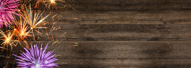Silvester background banner panorama long- firework  on rustic dark wooden texture, top view with space for text