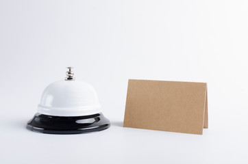 Closeup of reception call bell and table plate on the white background