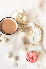 Cup of hot cocoa with marshmallows and christmas tree decorations on a white background. Christmas inspiration.