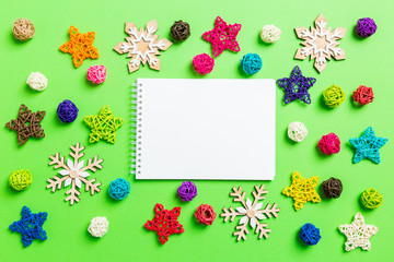 Top view of notebook. New Year decorations on green background. Festive stars and balls. Merry Christmas concept