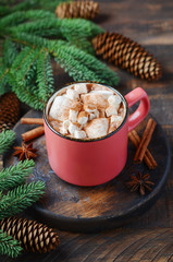Obraz na płótnie Canvas Hot chocolate with marshmallows on rustic wooden background. Christmas concept decorated with Fir branches and Cones.