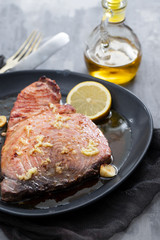 fried tuna with salt and lemon on dark plate